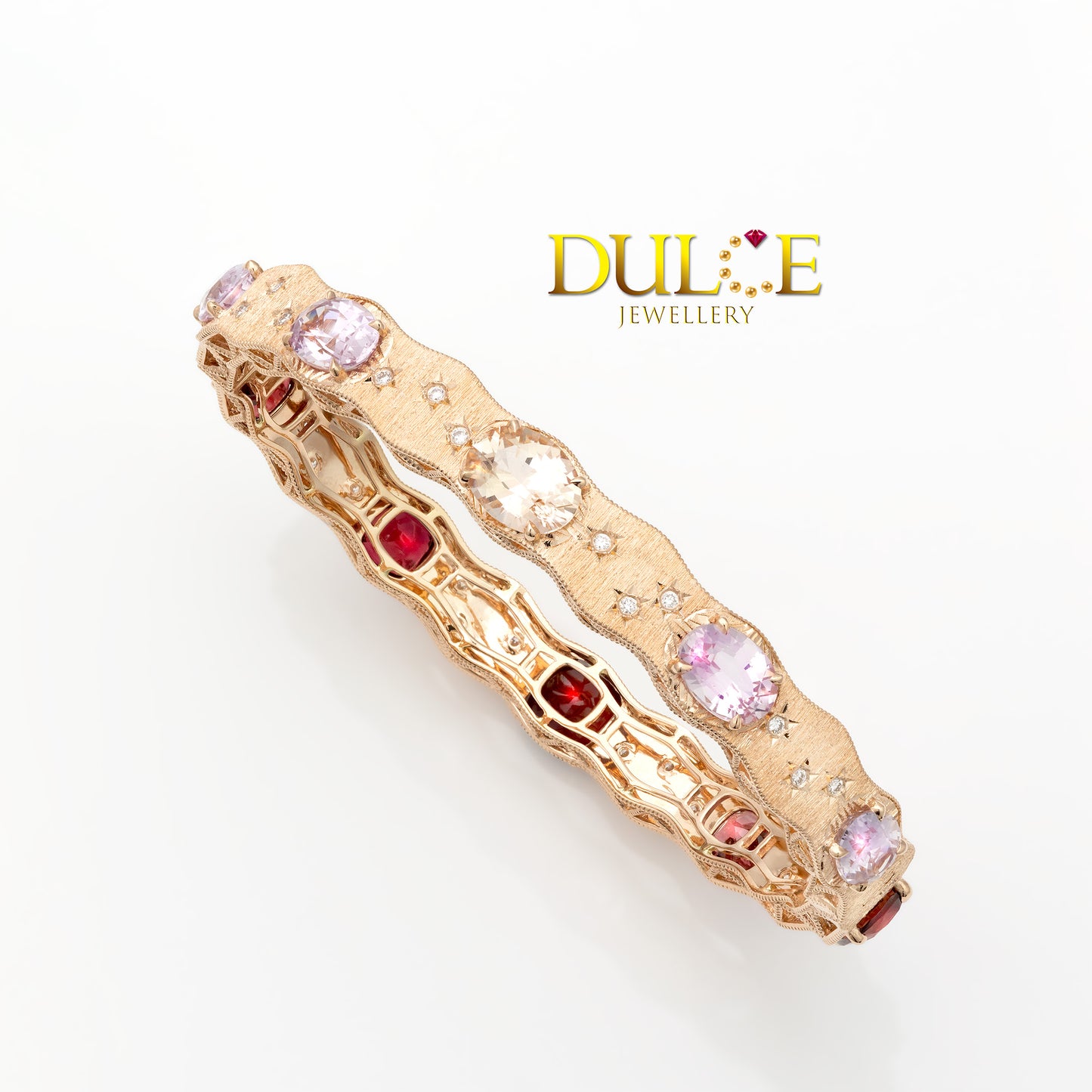 Gold bracelet with pink and red gemstones on a white background, featuring the Dulce Jewellery logo.