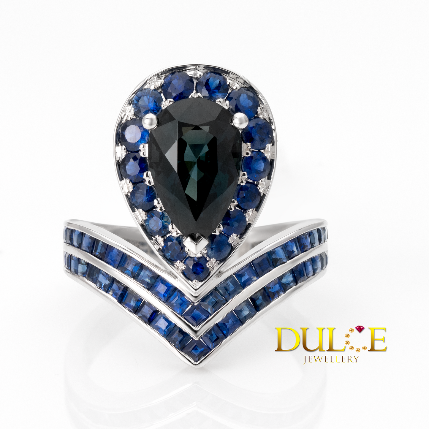 Jewelry ring with a central black gemstone and blue sapphire stones on a white background, featuring the Dulie Jewellery brand.