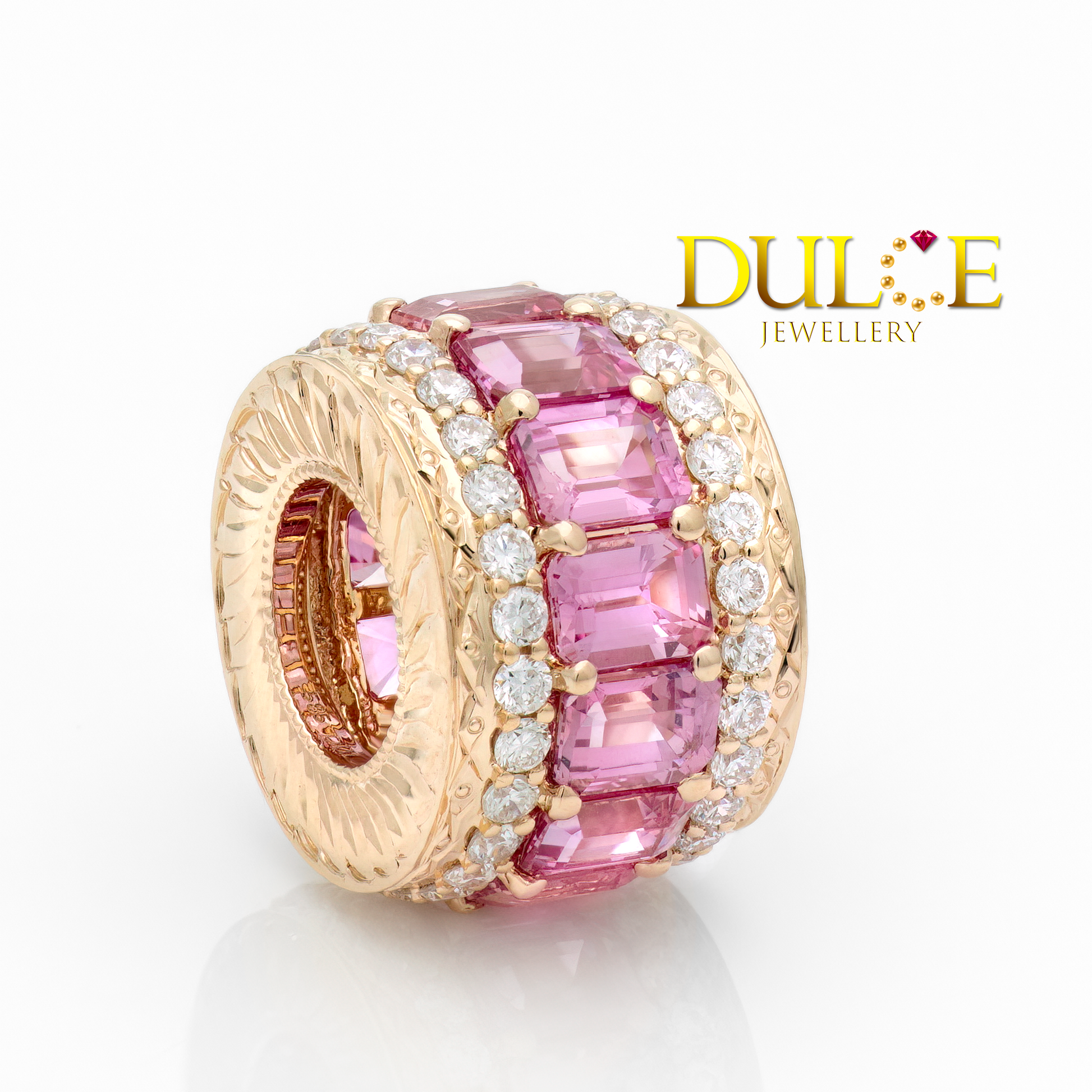 Jewelry charm with pink gemstones and gold accents on a white background, featuring the Dulce Jewellery logo.