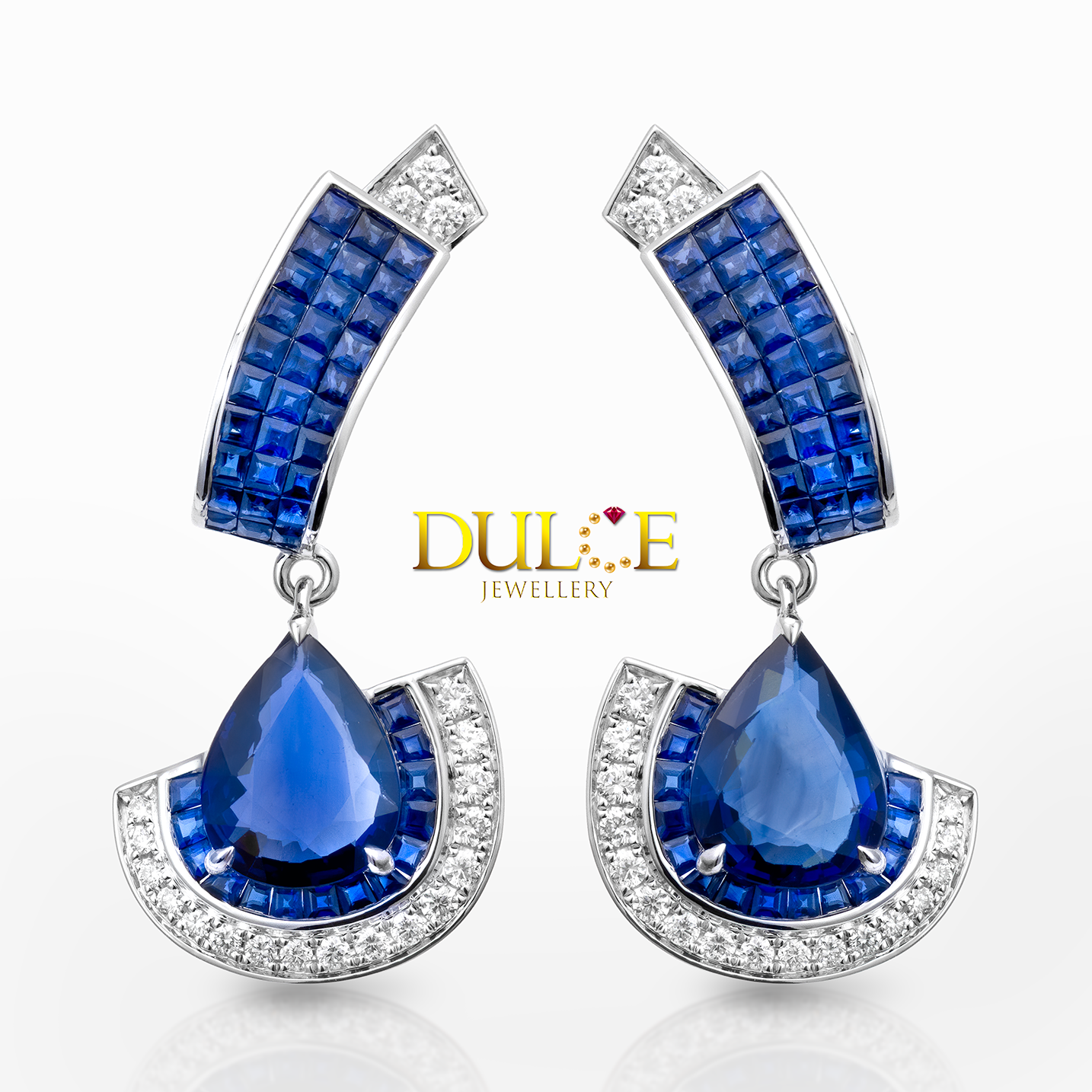 Blue teardrop sapphire earrings with gold accents on a white background, featuring the Dulice Jewellery logo.