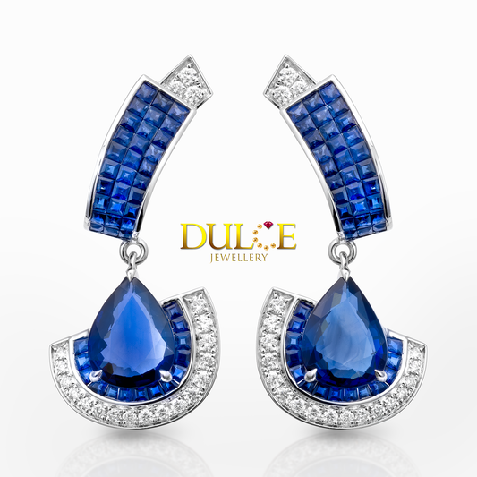 Blue teardrop sapphire earrings with gold accents on a white background, featuring the Dulice Jewellery logo.