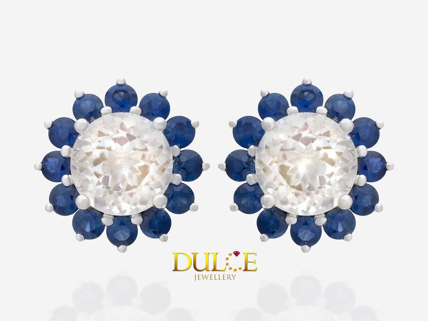 Round-shaped moonstone surrounded by a sparkling halo of blue sapphires, set in an elegant metal design.